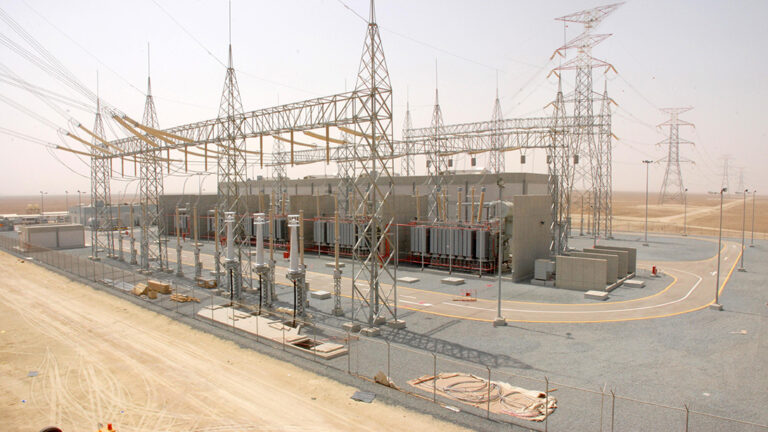 Oil-immersed power transformer with radiators and high-voltage bushings at an industrial project site
