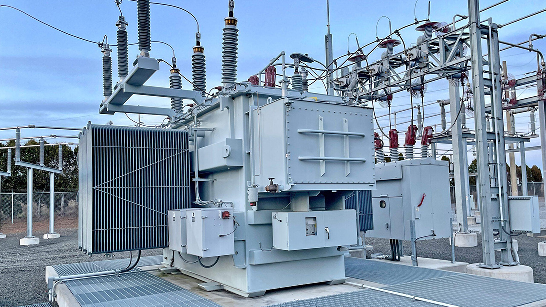 Outdoor oil-immersed transformer with bushings and cooling radiators in a switchyard
