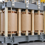 Assemblage de noyau et d'enroulements de transformateur triphasé avec des éléments de serrage structurels, réalisé en usine