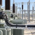 Illustrative outdoor substation scene showing current transformers and secondary cables routed toward a protection cabinet.